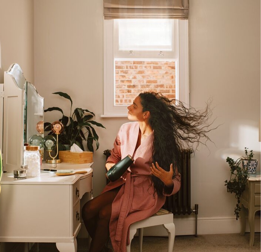 A customer drying her hair at home.